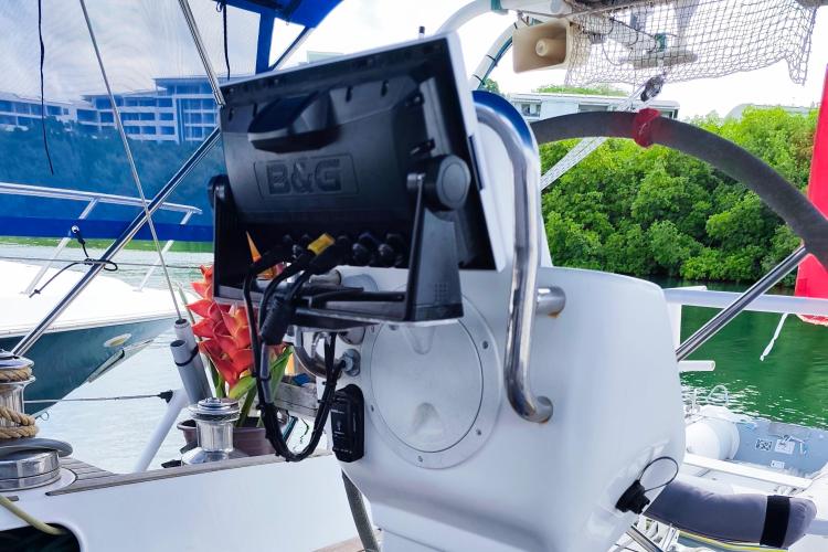 Cockpit of 2019 Custom Patago 40 sailboat with navigation equipment and lush greenery in background.