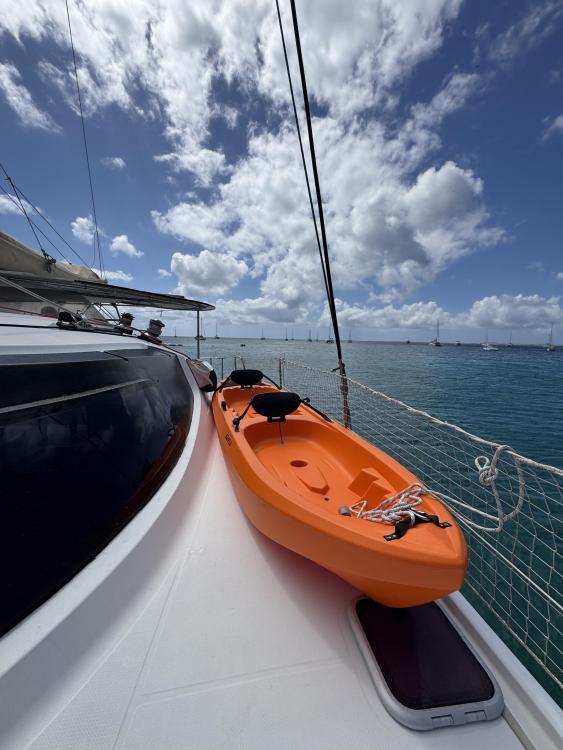 Orange kayak on 2006 Fountaine Pajot Bahia 46 catamaran deck, under blue sky.