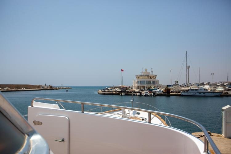 View from Benetti 33 yacht, 1972 model, overlooking a marina with boats and clear blue sky.