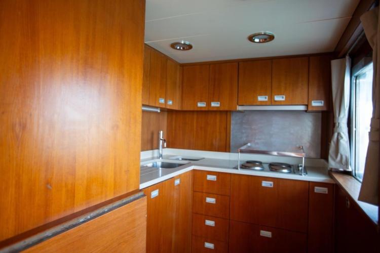 Vintage 1972 Benetti 33 yacht kitchen with wooden cabinetry and modern appliances.