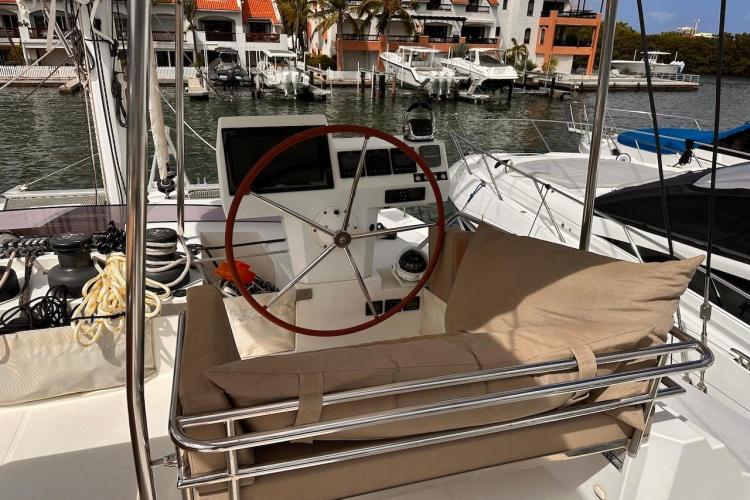 2016 Fountaine Pajot Ipanema 58 yacht helm with cushioned seating in marina setting.