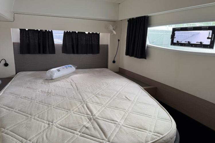Cozy bedroom in 2020 Fountaine Pajot Astrea 42 catamaran with large bed and windows.