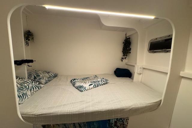 Cozy cabin interior of 2004 Etoile Marine Maxi Cat 24 with bed and porthole.