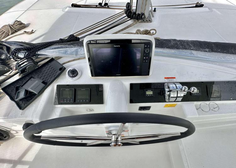 Helm station of 2023 Lagoon 46 catamaran with navigation equipment and steering wheel.