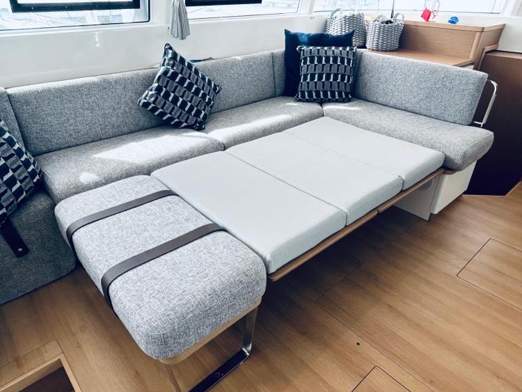 Modern interior of 2024 Excess 14 yacht with convertible sofa bed.