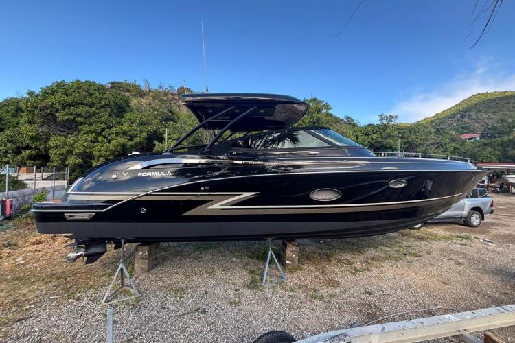 2018 Formula 350 Crossover Bowrider boat on land, black exterior, scenic background.