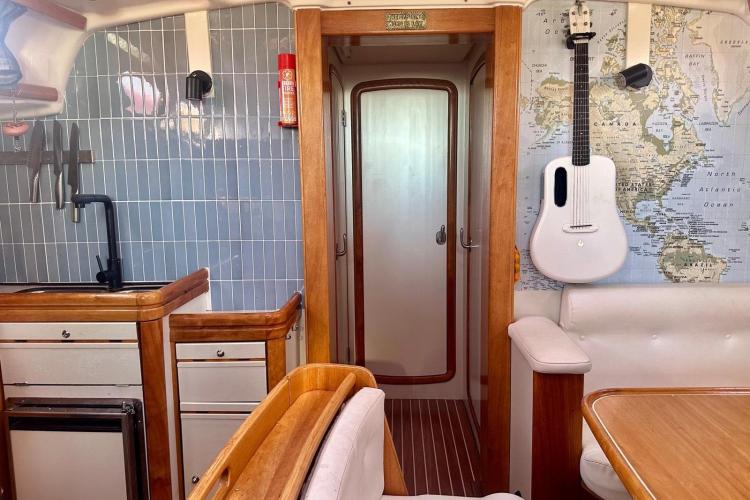 Interior of 2006 Bavaria Cruiser 46 yacht with kitchen, map, and guitar.