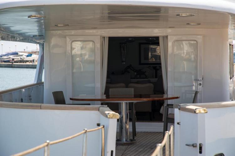 Aft deck of 1972 Benetti 33 yacht with outdoor seating and table.