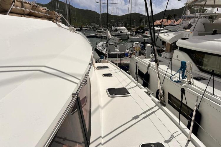 2016 Fountaine Pajot Ipanema 58 catamaran docked in a marina, surrounded by other yachts.