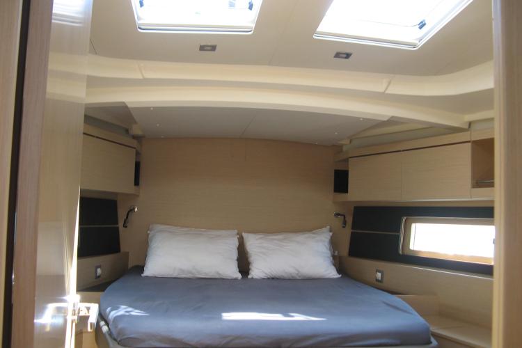 Interior cabin of 2019 Beneteau Oceanis 46.1 yacht with skylights and cozy bedding.