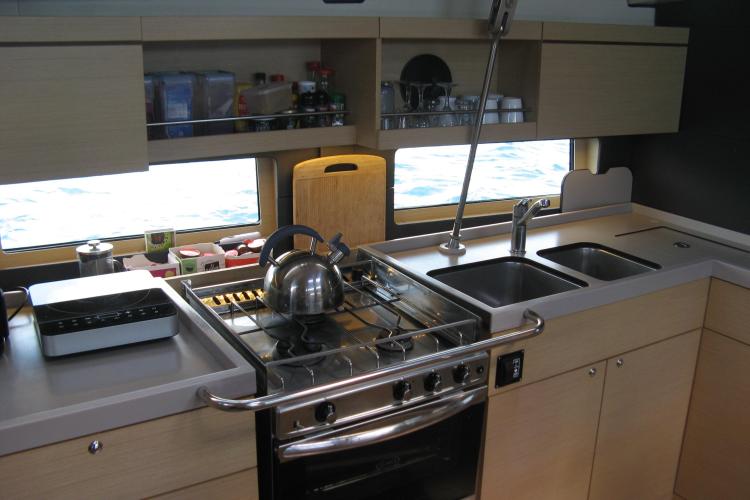 Modern kitchen in a 2019 Beneteau Oceanis 46.1 yacht with stove and sink.