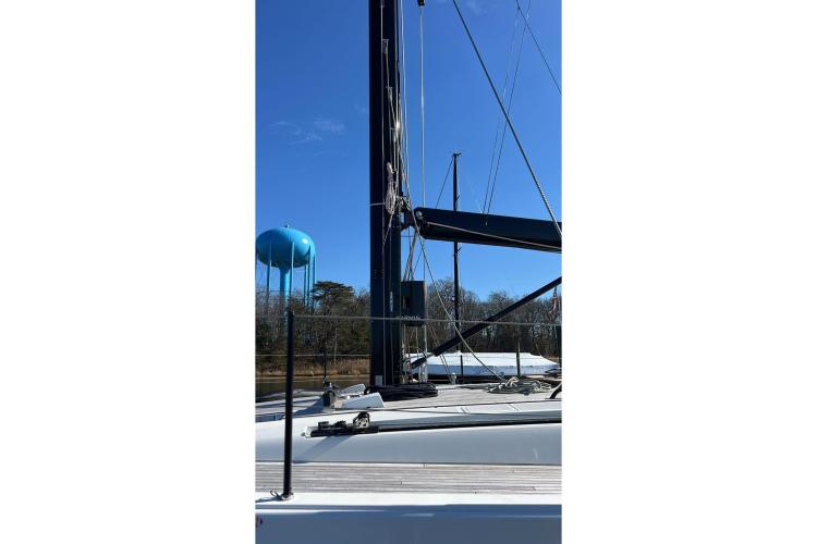 2024 Beneteau First 53 sailboat mast and deck under clear blue sky.