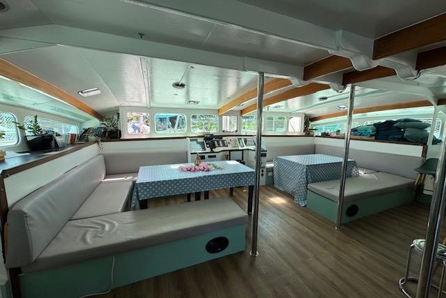 Spacious interior of 2004 Etoile Marine Maxi Cat 24 catamaran with seating and tables.