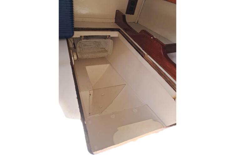 Interior storage compartment of 1986 Dufour CATALINA sailboat, featuring wooden trim and shelving.