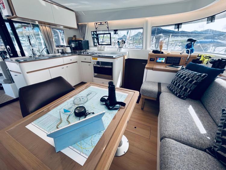 Luxurious interior of 2024 Excess 14 yacht with modern kitchen and navigation table.