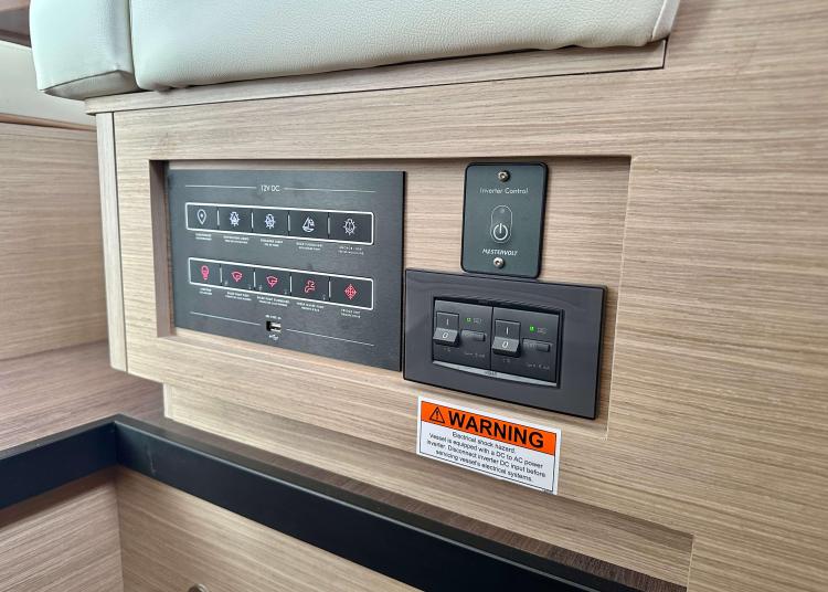 Control panel on 2023 Lagoon 46 yacht interior with warning label.