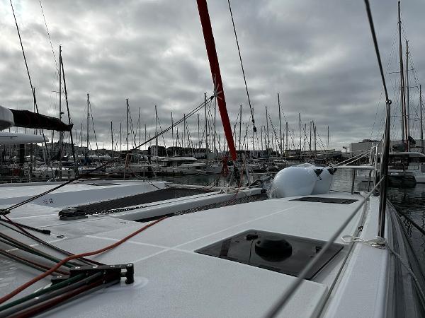 2024 Excess 11 catamaran docked in a marina under cloudy skies.