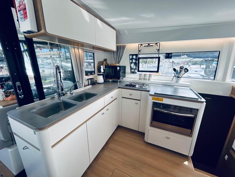 Modern kitchen interior of 2024 Excess 14 yacht with sleek design and appliances.