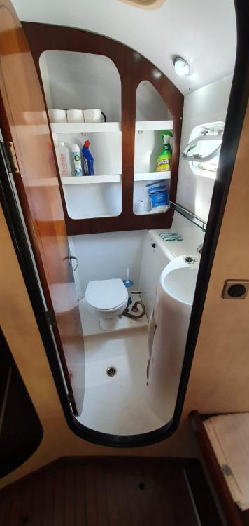 1999 Fountaine Pajot Bahia 46 yacht bathroom with toilet, sink, and storage shelves.