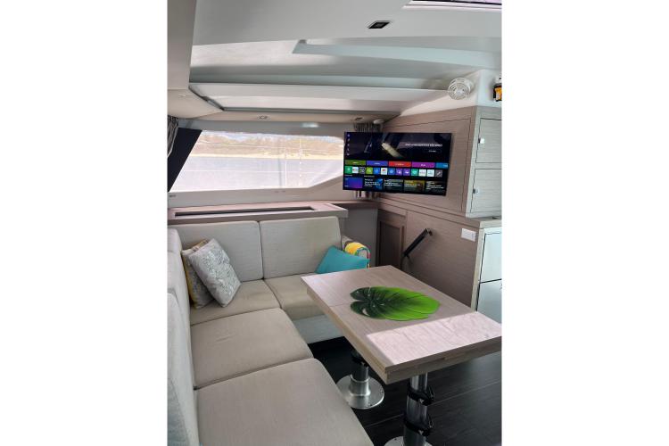 Luxurious interior of 2023 Fountaine Pajot Astrea 42 Catamaran with modern seating and entertainment system.