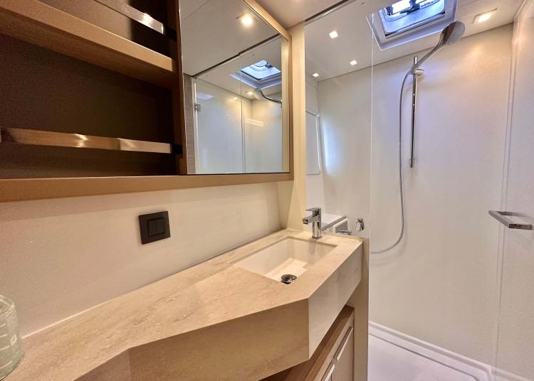 Modern bathroom in 2023 Lagoon 46 yacht with sleek sink and shower.