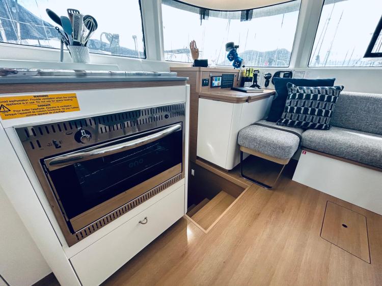 Modern interior of 2024 Excess 14 yacht with kitchen and seating area.