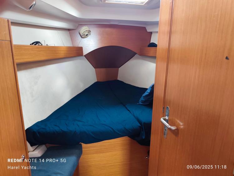 Cozy cabin interior of 2005 Beneteau Cyclades 43.3 yacht with blue bedding.