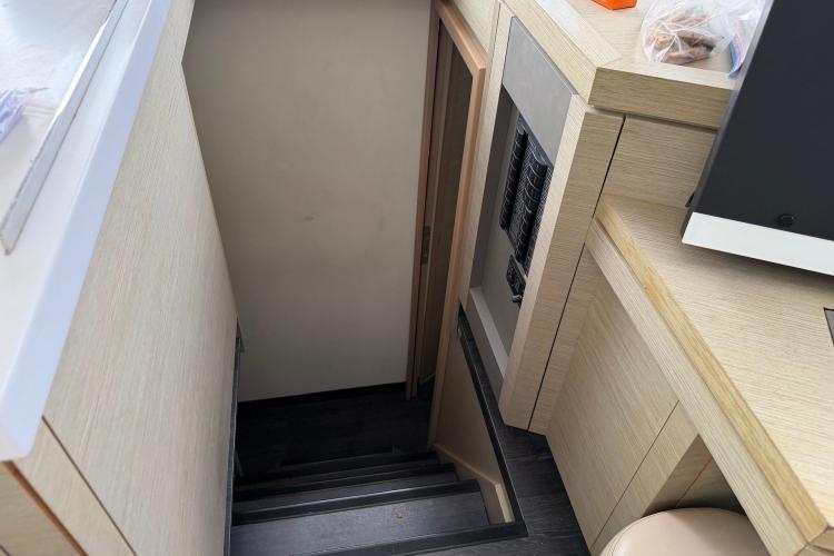 Interior stairs of 2020 Fountaine Pajot Astrea 42 catamaran, featuring modern wood finish.