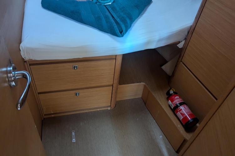 Cabin interior of 2017 Dufour 460 Grand Large with bed, drawers, and fire extinguisher.