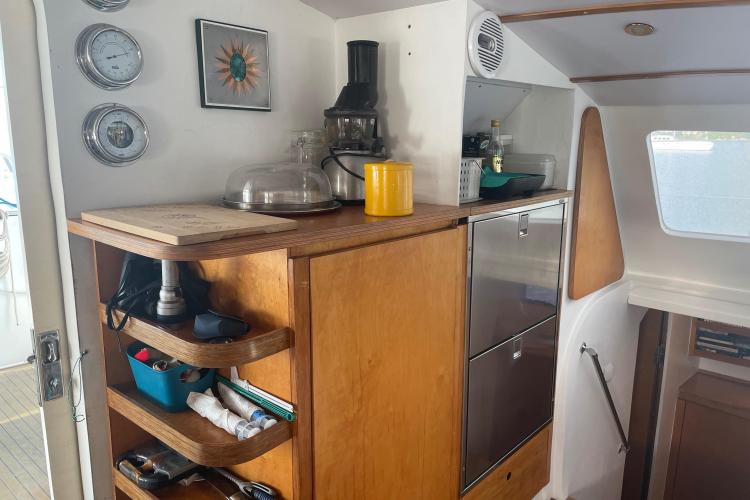 Cozy boat interior with wooden cabinets, kitchen appliances, and nautical decor. Custom KSENIA 149, 2010.