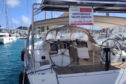 2017 Dufour 460 Grand Large yacht docked, featuring spacious cockpit and sales sign.