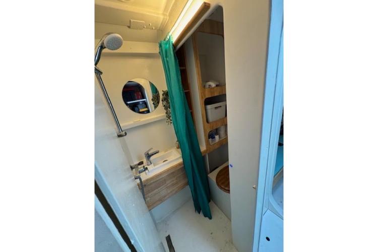 Compact bathroom in 2004 Etoile Marine Maxi Cat 24, featuring shower, sink, and storage.