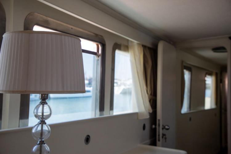 Interior of 1972 Benetti 33 yacht with elegant lamp and window view.