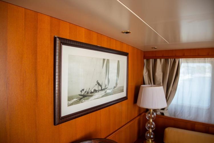Interior of 1972 Benetti 33 yacht with framed sailing photo and elegant lamp.