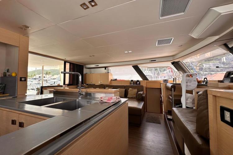 Luxurious interior of 2016 Fountaine Pajot Ipanema 58 catamaran with modern kitchen and seating area.