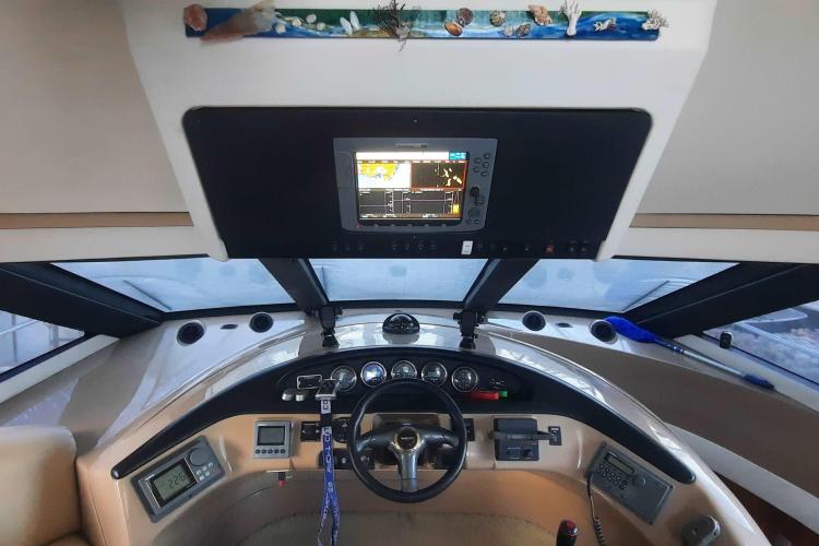 2000 Carver 530 Voyager Pilothouse helm with navigation equipment and steering wheel.