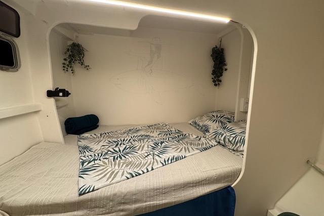 Cozy cabin interior of 2004 Etoile Marine Maxi Cat 24 with leafy bedding and decor.