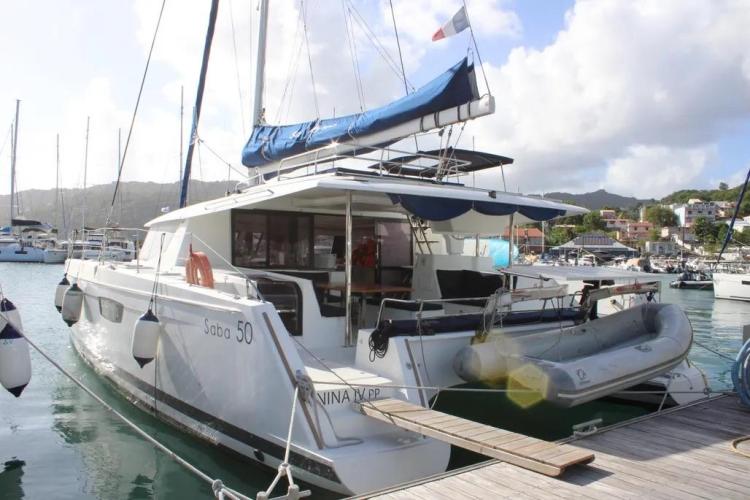 2017 Fountaine Pajot SABA 50 catamaran docked at marina with inflatable dinghy.