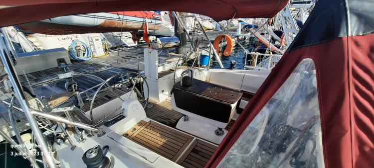 2007 Elan Impression 434 yacht cockpit with wooden deck and red canopy.